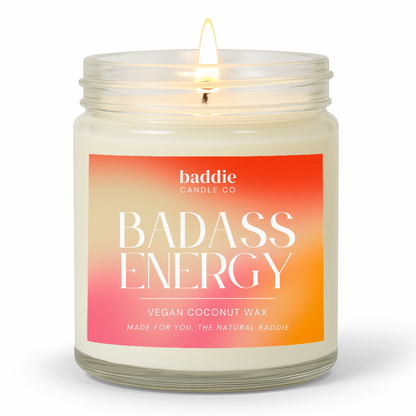 Candle in a clear glass jar with a colorful gradient 'Badass Energy' label with a white background