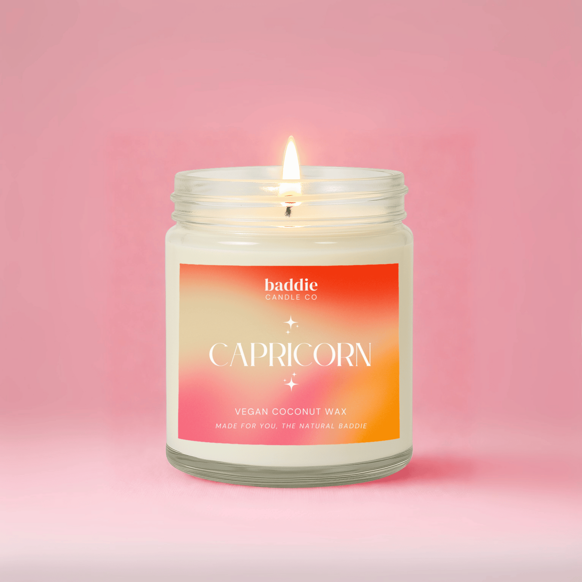 Candle in a jar with a colorful label reading 'Capricorn' on a pink background
