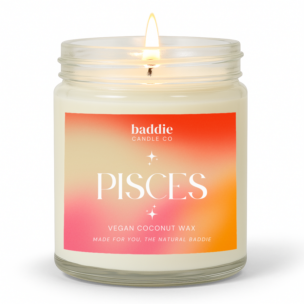 A clear jar candle with a colorful pink hued gradient label with the text, Pisces, Vegan Coconut Wax, by Baddie Candle Co.