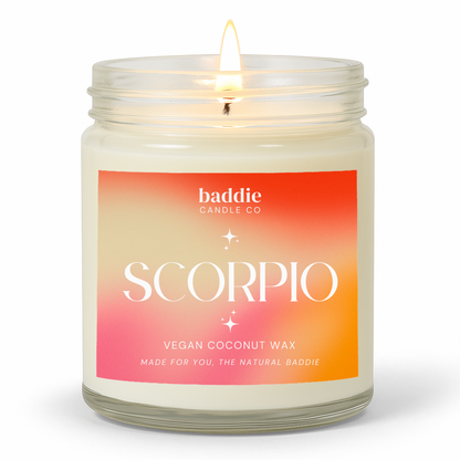A clear jar candle with a colorful pink hued gradient label with the text, SCORPIO, Vegan Coconut Wax, by Baddie Candle Co.